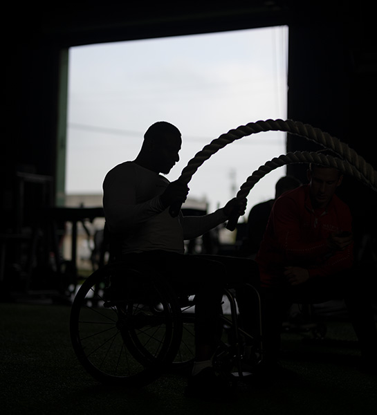 Kenneth Keitt featured in silhouette as he works out with battle ropes